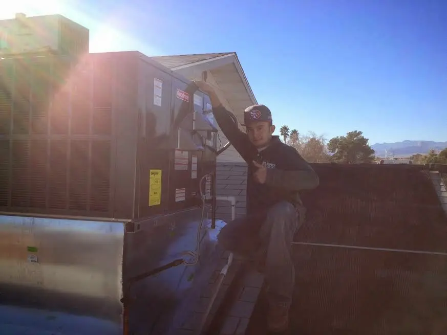 HVAC technician performing Air Duct Cleaning on a rooftop unit in Diamond Springs